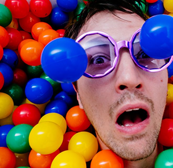 Un chico en bañera llena de pelotas multicolor en escape room "After-Party" de Lock-Clock